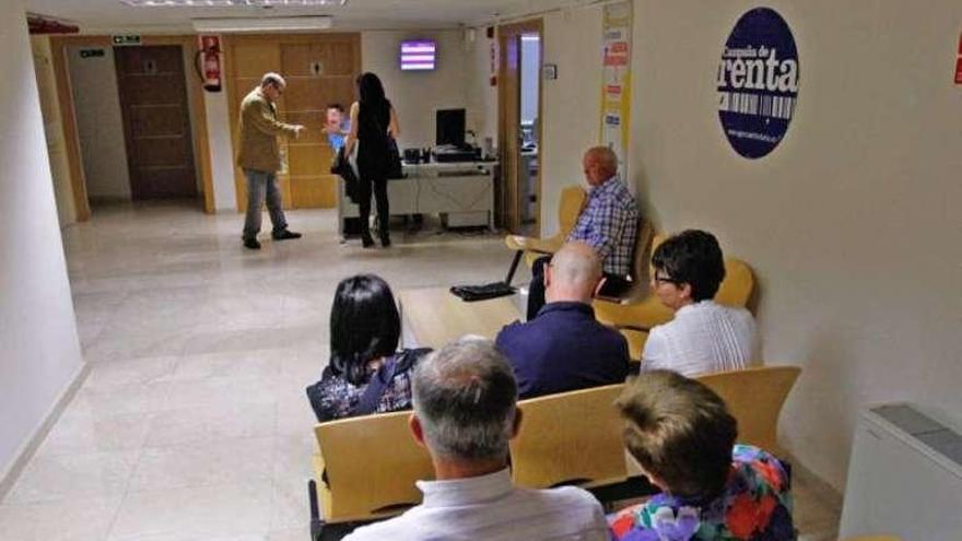 Ciudadanos esperan en las oficinas de Hacienda.