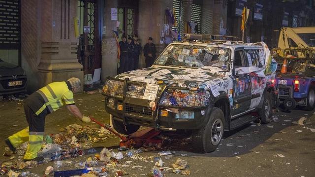 La grua se lleva los vehículos de la Guardia Civil delante de la Conselleria de Economia de la Generalitat custodiada por los Mossos