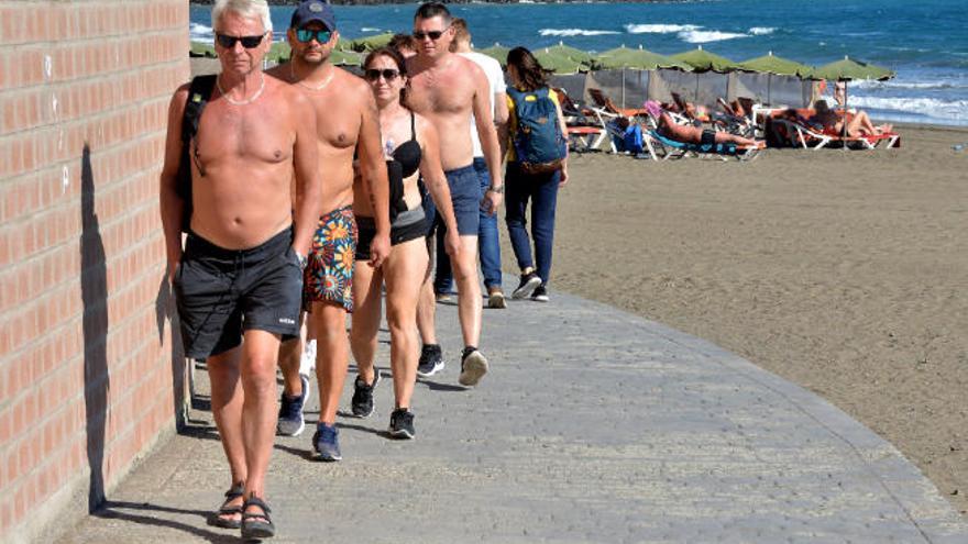 Turistas paseando por la playa de San Agustín.