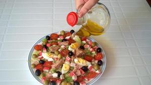 Aliño de una ensalada con una aceitera.