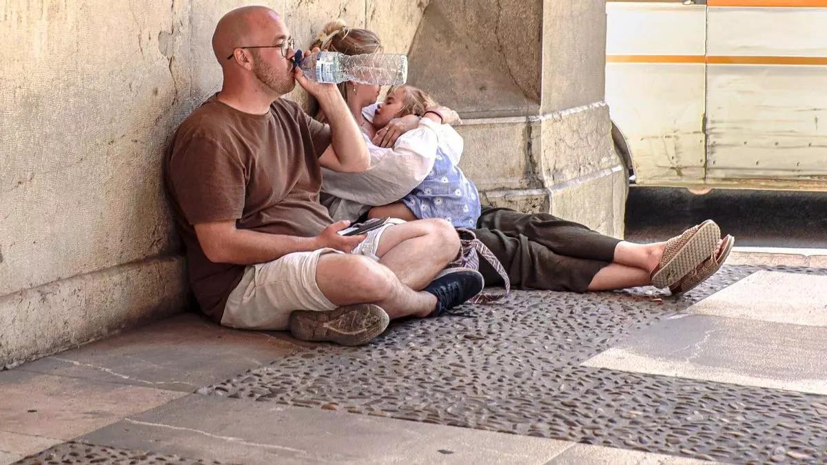 Urlauber in Palma suchen an einem schattigen Ort Schutz vor der Hitze.