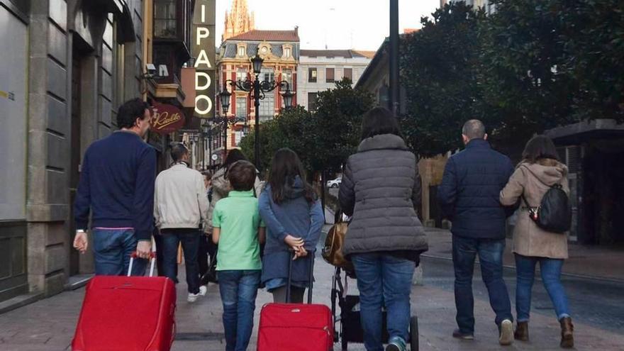Turistas con maletas por las calles de Oviedo.