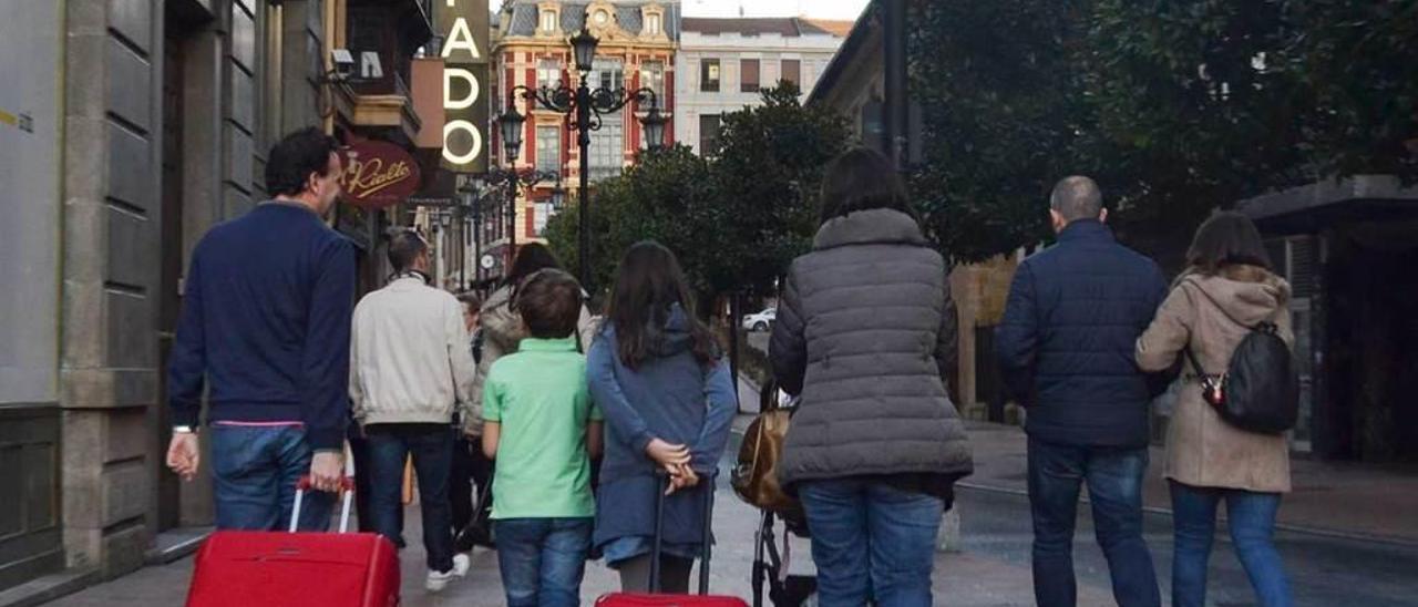 Turistas con maletas por las calles de Oviedo.