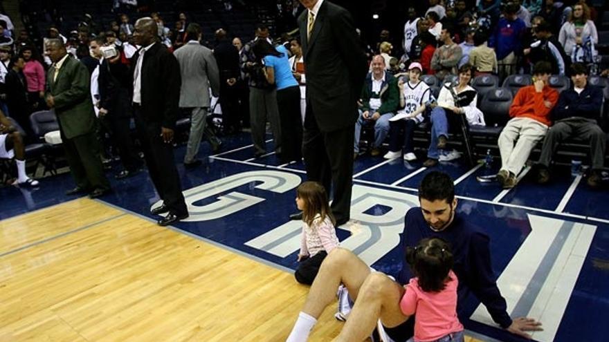 Navarro juega con sus dos hijas antes del comienzo de un partido ante la mirada de su entrenador.