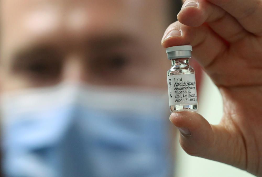 A pharmacist displays an ampoule of ...