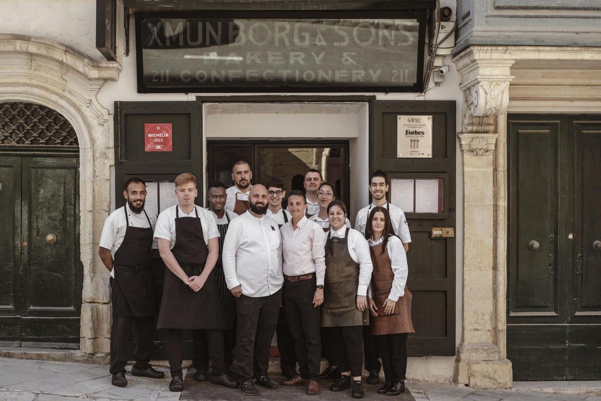El equipo del restaurante Nini con el cartel de la antigua panadería