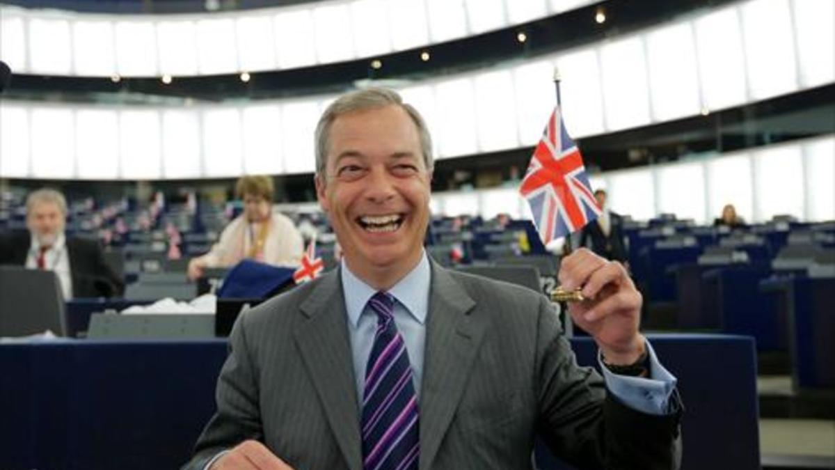 Nigel Farage, exlíder del partido xenófobo británico UKIP, sostiene una banderita de la Union Jack.