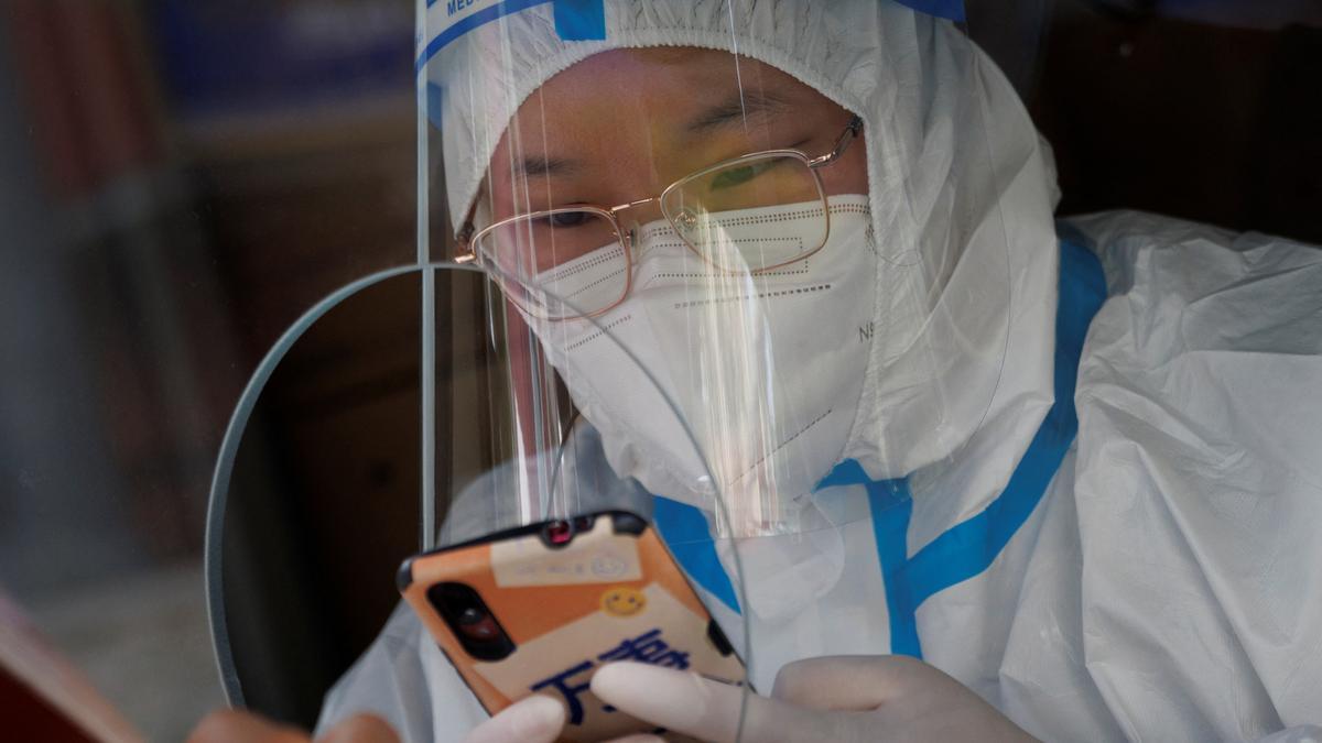 A pandemic prevention worker enters the personal information of a person in a nucleic acid testing booth following a coronavirus disease (COVID-19) outbreak in Beijing