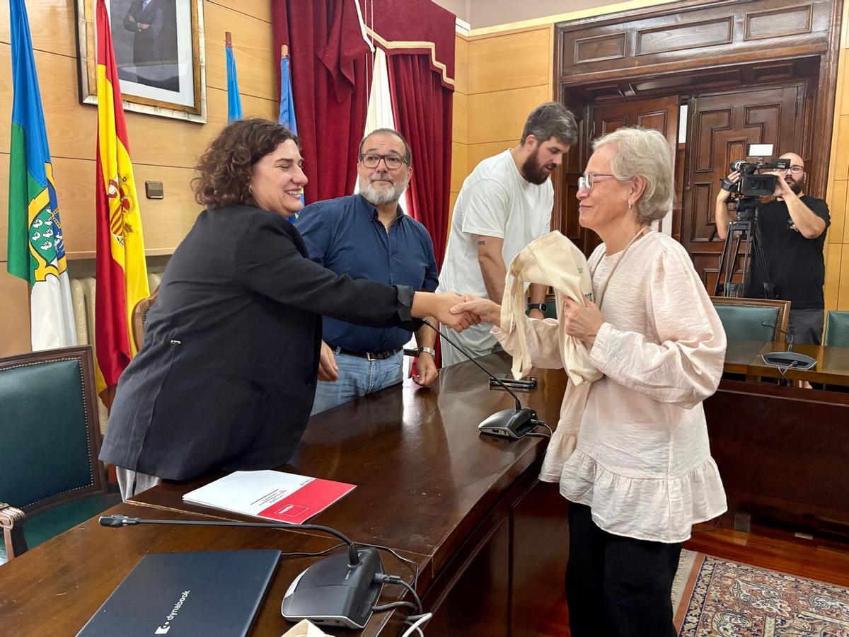 Ángela Iris Molina recibe la documentación y las llaves de su nueva casa de manos de la gerente de Vipasa, Marta Pulgar, en el Ayuntamiento de Langreo