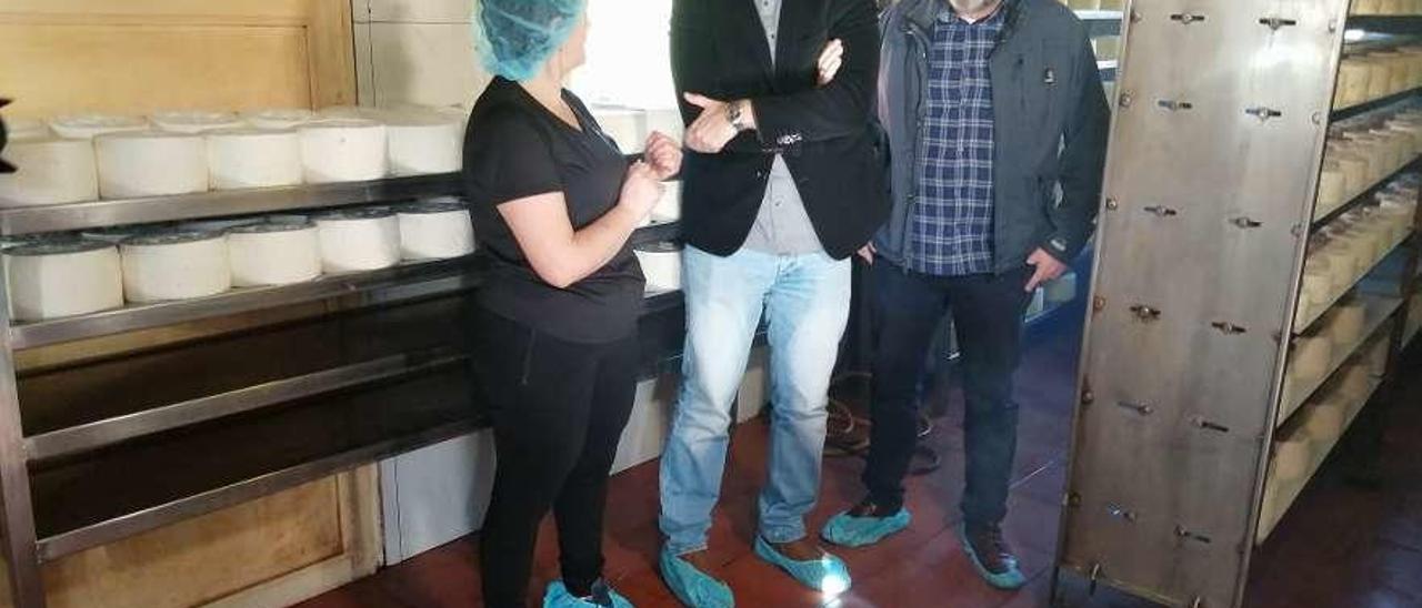 La productora Rosa Sánchez, junto al consejero Borja Sánchez y el alcalde de Onís, José Manuel Abeledo, en la sala de ahumado de la quesería Vega de Ariu de Benia.