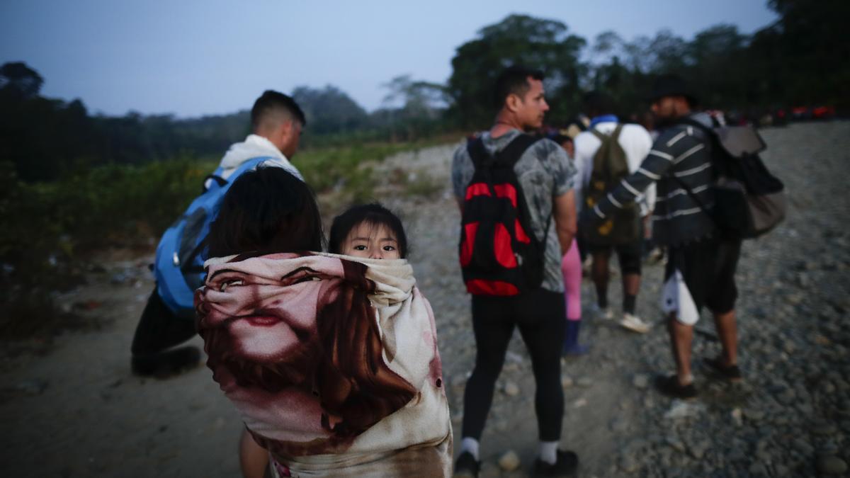 Adultos y niños migrantes hacen fila en Bajo Chiquito (Panamá) para ser trasladados a la Estación de Recepción Migratoria