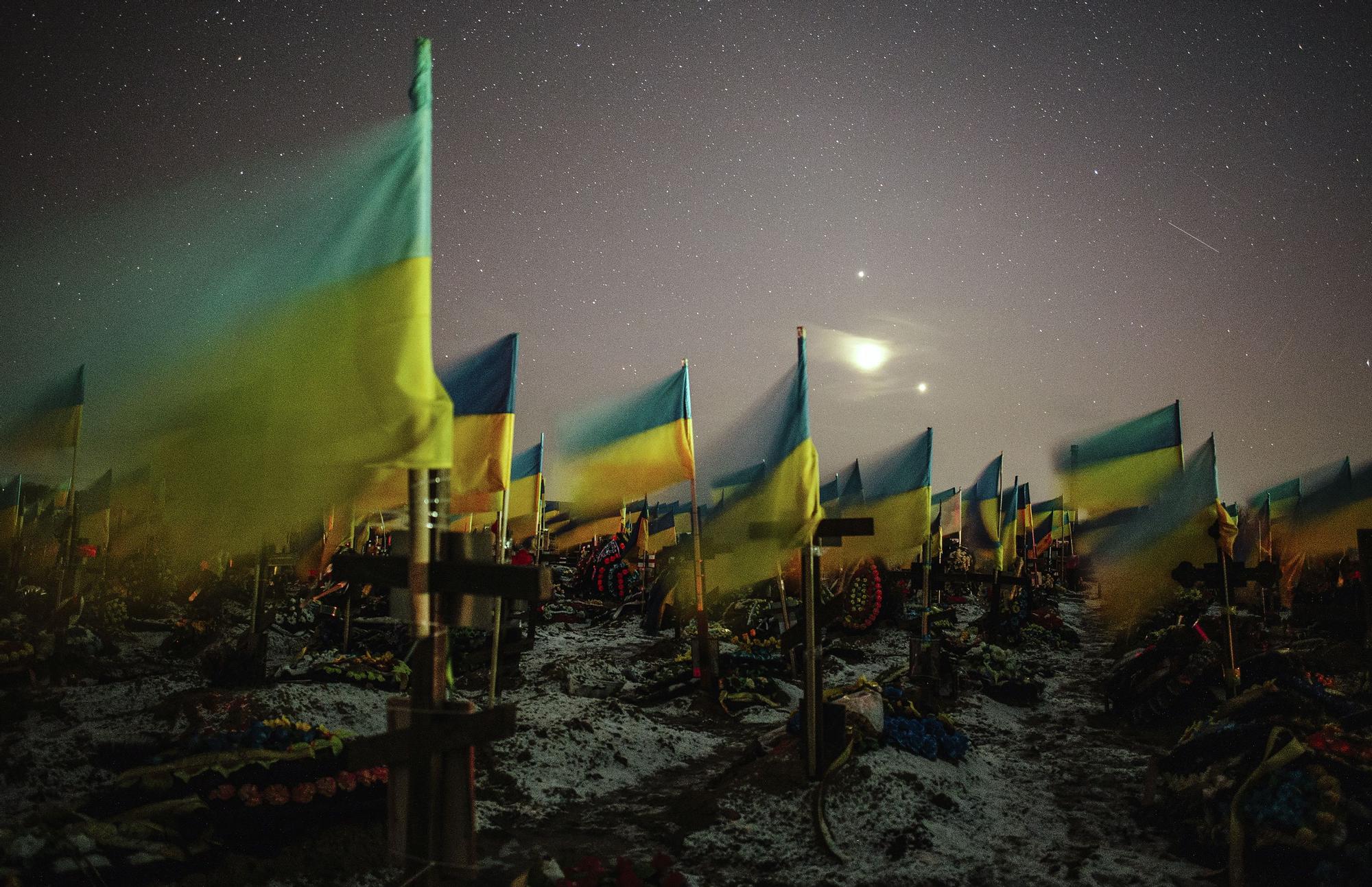 Banderas ucranianas marcan las tumbas de soldados caídos en el cementerio de Járkov.