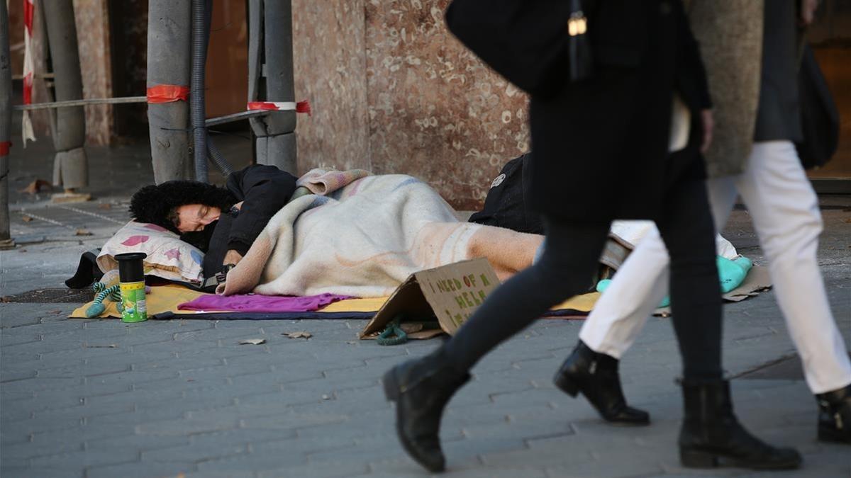 Un hombre duerme en Paseo de Gràcia, el pasado mes de noviembre.