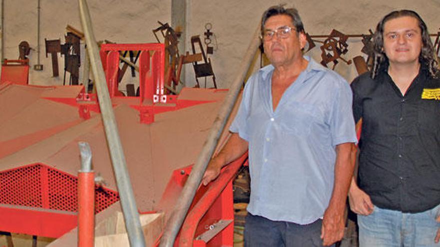 Pedro Serra y su hijo, junto a una de las máquinas que fabrican en su taller.