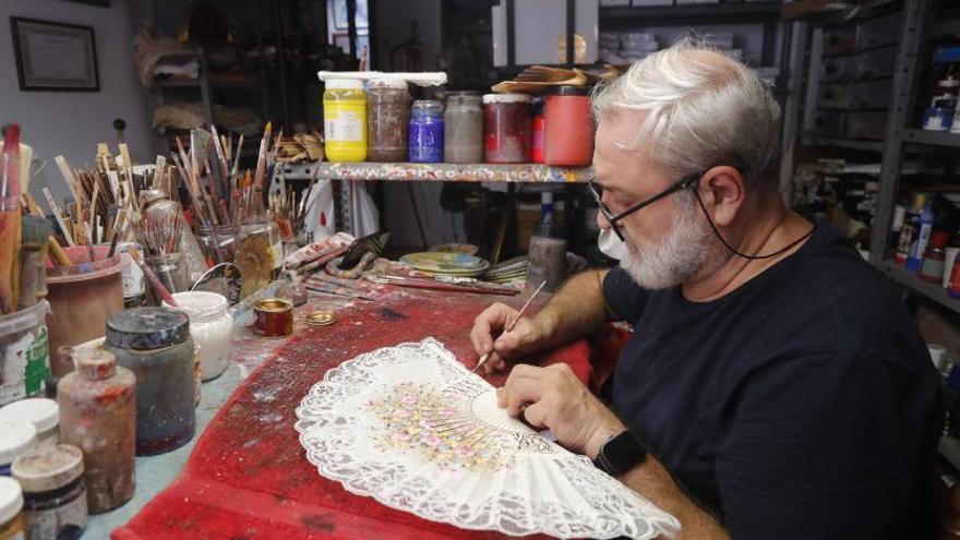 El artesano Vicente Benlloch pinta un abanico en su taller-tienda Vibenca. | J.M. LÓPEZ