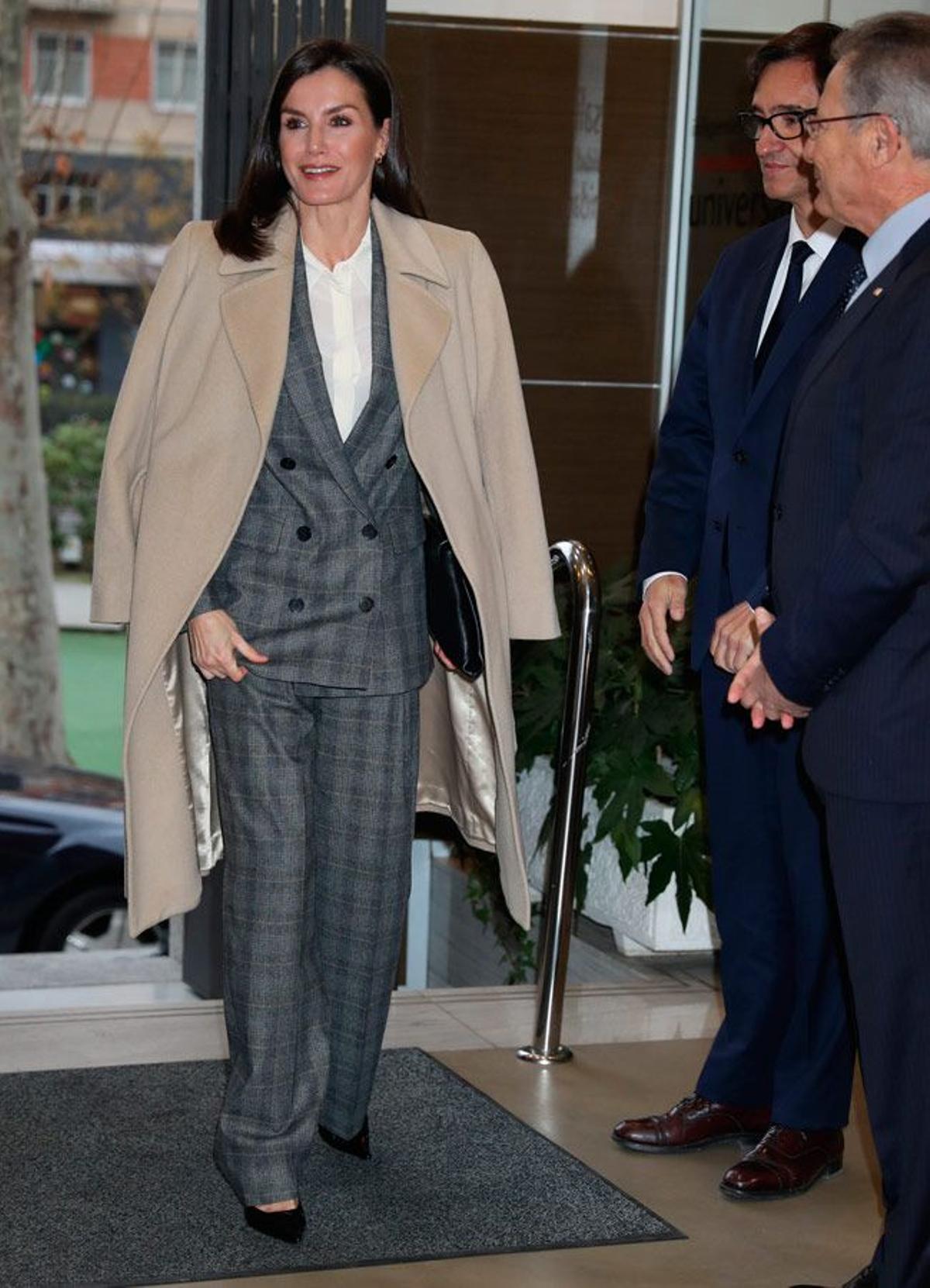 La reina Letizia con traje de chaqueta y pantalón de estilo masculino y abrigo camel
