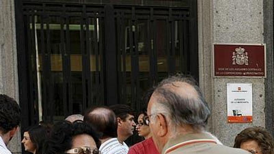 Dos miembros de la Asociación de Afectados Fórum Madrid conversan durante la manifestación que han protagonizado esta mañana en la puerta de los juzgados mercantiles de Madrid para reclamar una solución.