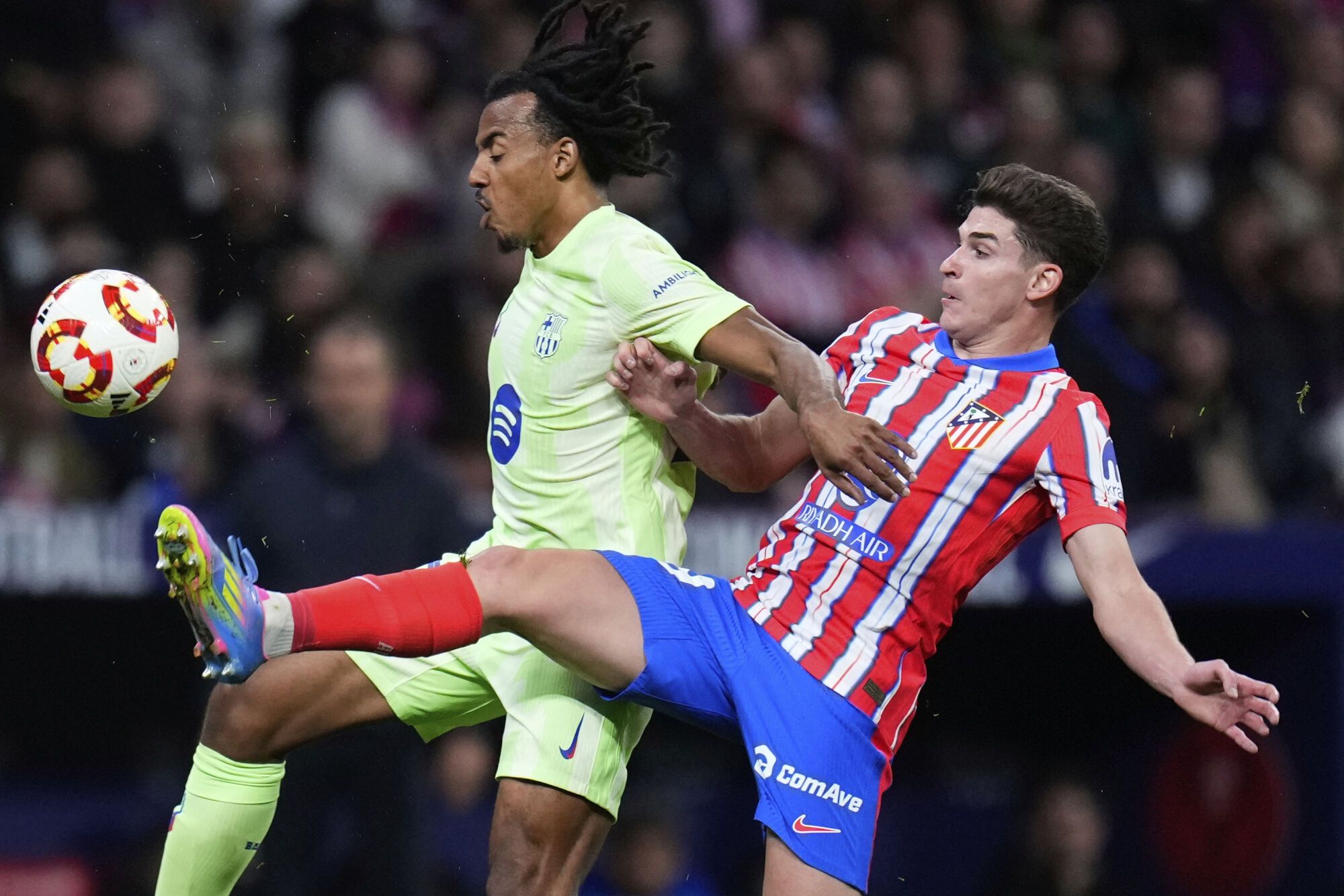 Barcelona's Jules Kounde, left, and Atletico Madrid's Julian Alvarez fight for the ball during the Spanish Copa del Rey semifinal second leg soccer match between Atletico Madrid and Barcelonaat the in Madrid, Spain, Wednesday, April 2, 2025. (AP Photo/Manu Fernandez)