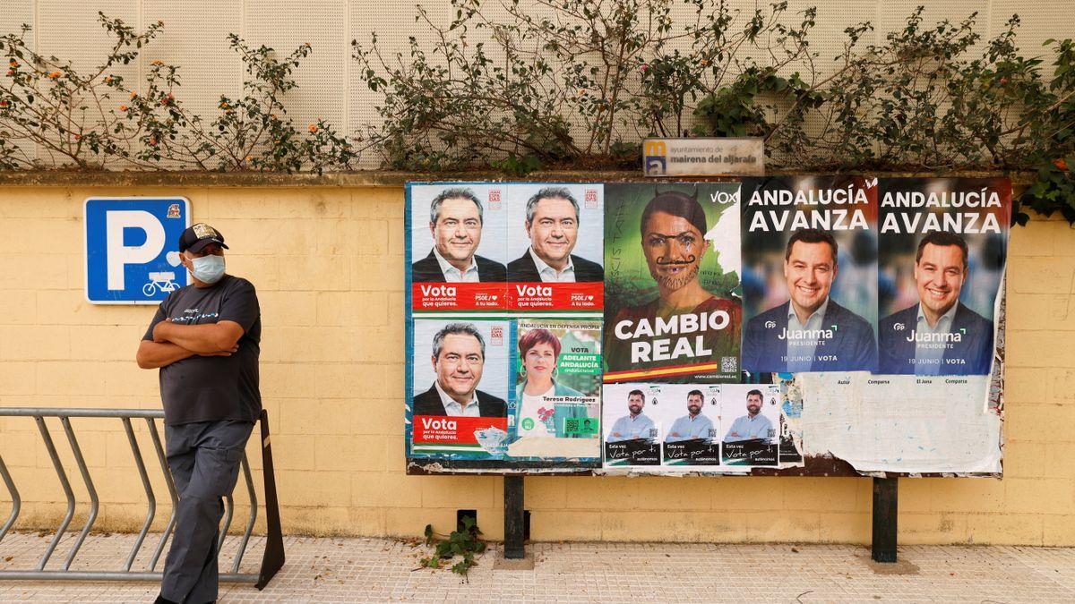 Un hombre frente a unos carteles electorales de las elecciones en Andalucía, en Mairena de Aljarafe, Sevilla.