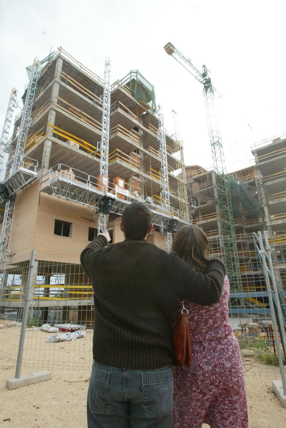 Una pareja observa un bloque de viviendas en construcción en Castellón.