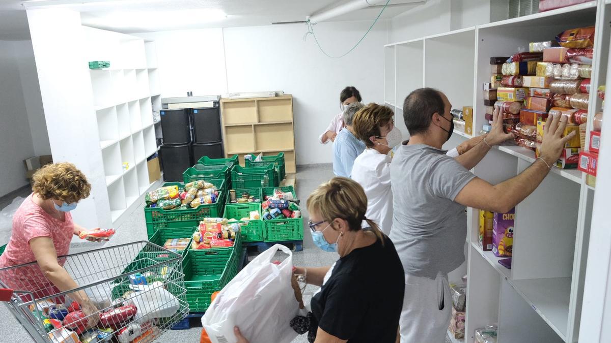 El personal de Cáritas organizando los alimentos entregados por los vecinos durante la Ofrenda a la Virgen del Remedio.