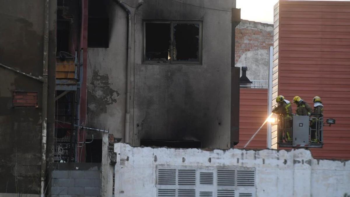 Los bomberos trabajan en la extinción del incendio de la nave ocupada en Badalona