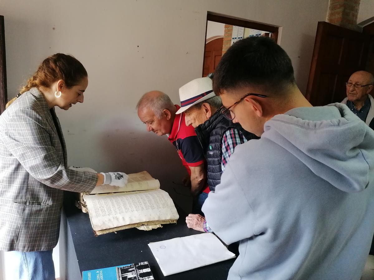 Participantes en la visita admiran un libro del año 1505