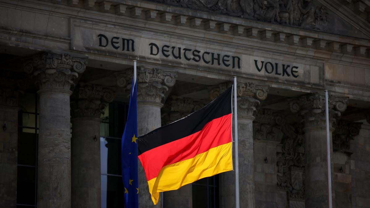 La bandera alemana ondea frente al edificio del Reichstag.