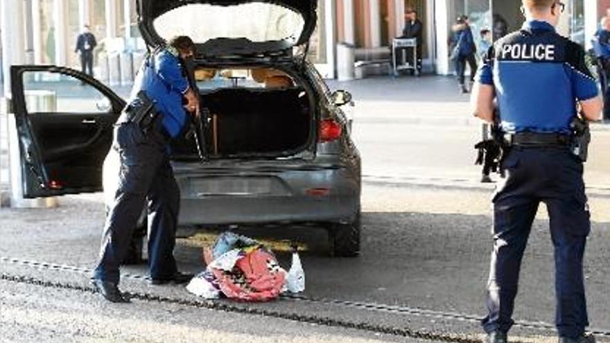 Dos agents escorcollen un cotxe a Ginebra, on s&#039;ha elevat el nivell d&#039;alerta terrorista.