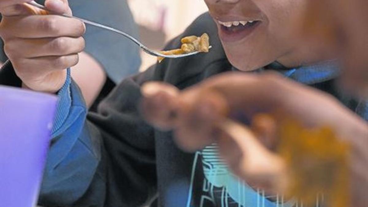 Unos niños en un comedor social de una entidad en el barrio del Raval, en Barcelona.