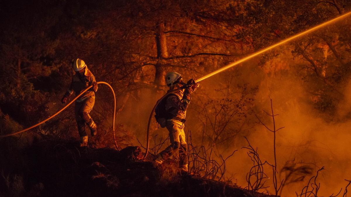 Bomberos forestales trabajando en la extinción por la noche.