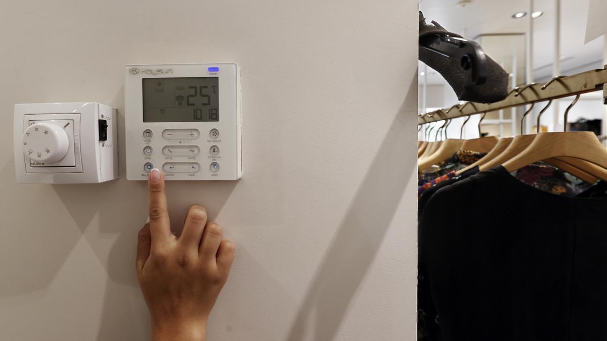 Una persona regula la temperatura del aire acondicionado.