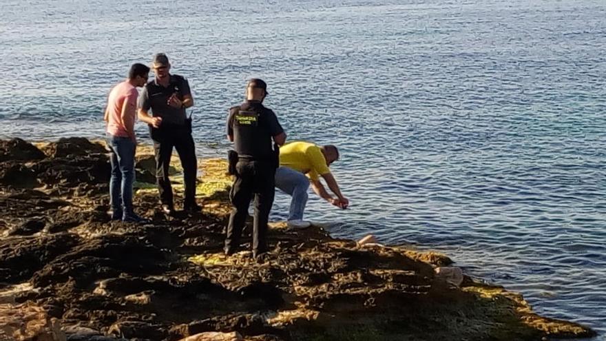 Los agentes rescatando el cadáver del agua