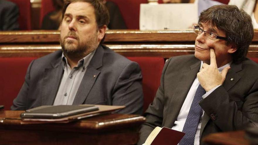 Junqueras y Puigdemont en el tenso pleno vivido ayer en el Parlamento catalán. // Efe