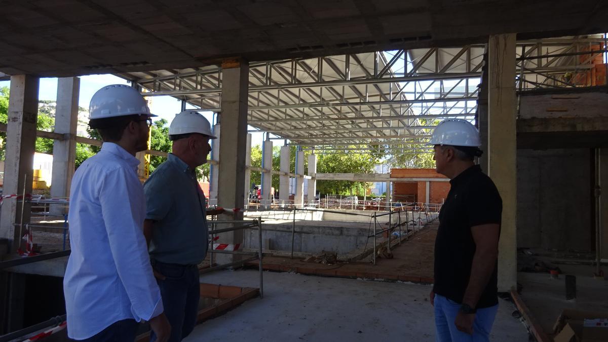 El alcalde, José Chulvi, el edil de Deportes, Alberto Tur y el director de la obra, con la piscina de fondo