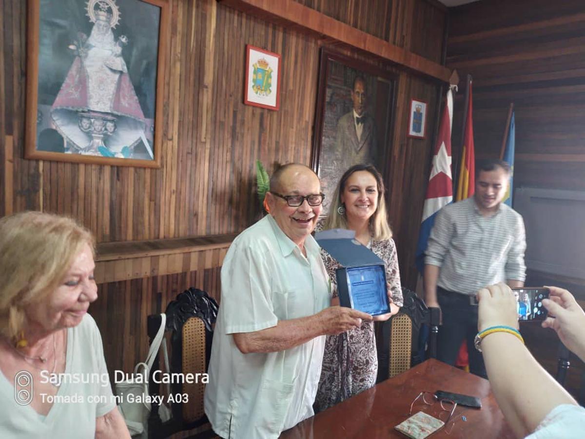 Longinos Valdés, en el centro, recibe un premio por su compromiso con la comunidad asturiana en Cuba.