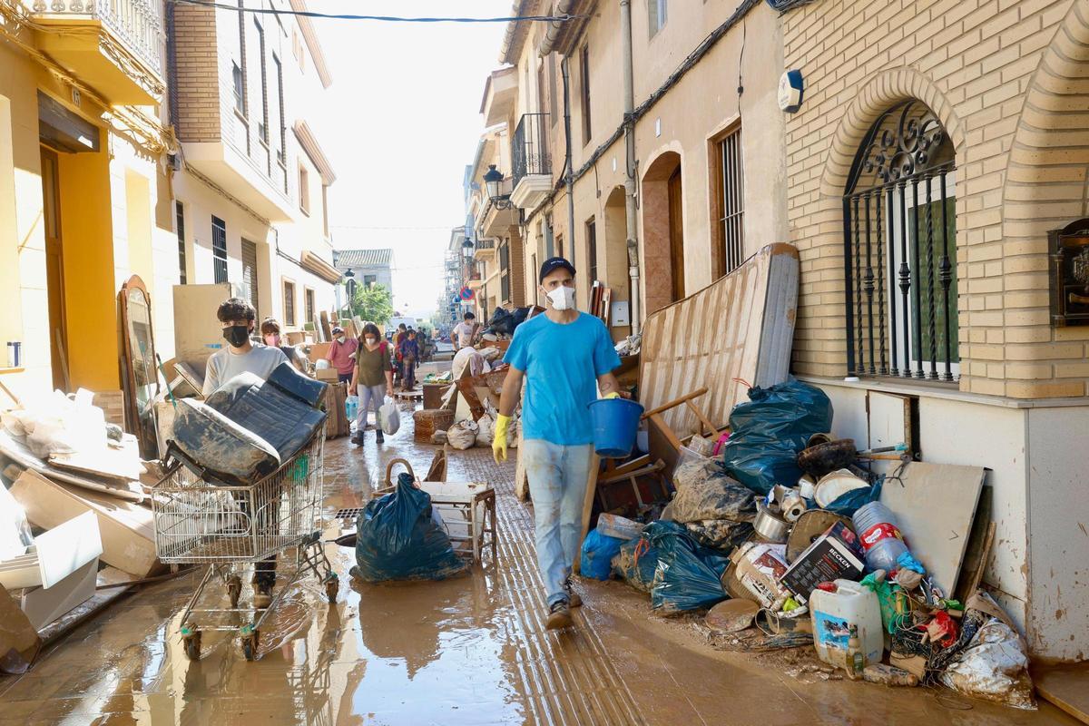 Los vecinos de Llocnou sacan los enseres a las calles llenos de lodo.