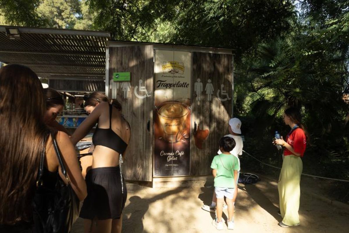 Gente esperando junto a los lavabos abiertos en el chiringuito de la cascada del parque de la Ciutadella.