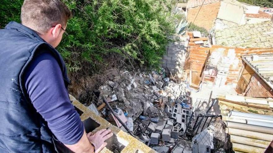 Uno de los vecinos de la calle Castillo de Sax afectado por los derrumbes muestra los daños sufridos y los residuos arrojados sobre las casas tras ser retirados de la ladera.