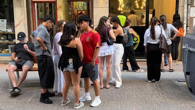 Colas de jóvenes ante una copistería para estampar sus camisetas de peñas.
