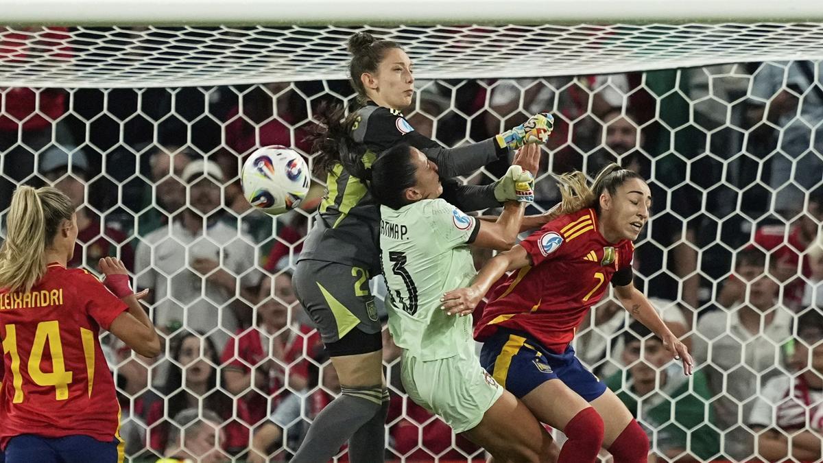 Adriana Nanclares, the goalkeeper of Spain, clears of fists against Fatima Pinto, the Portuguese player, in Bern.