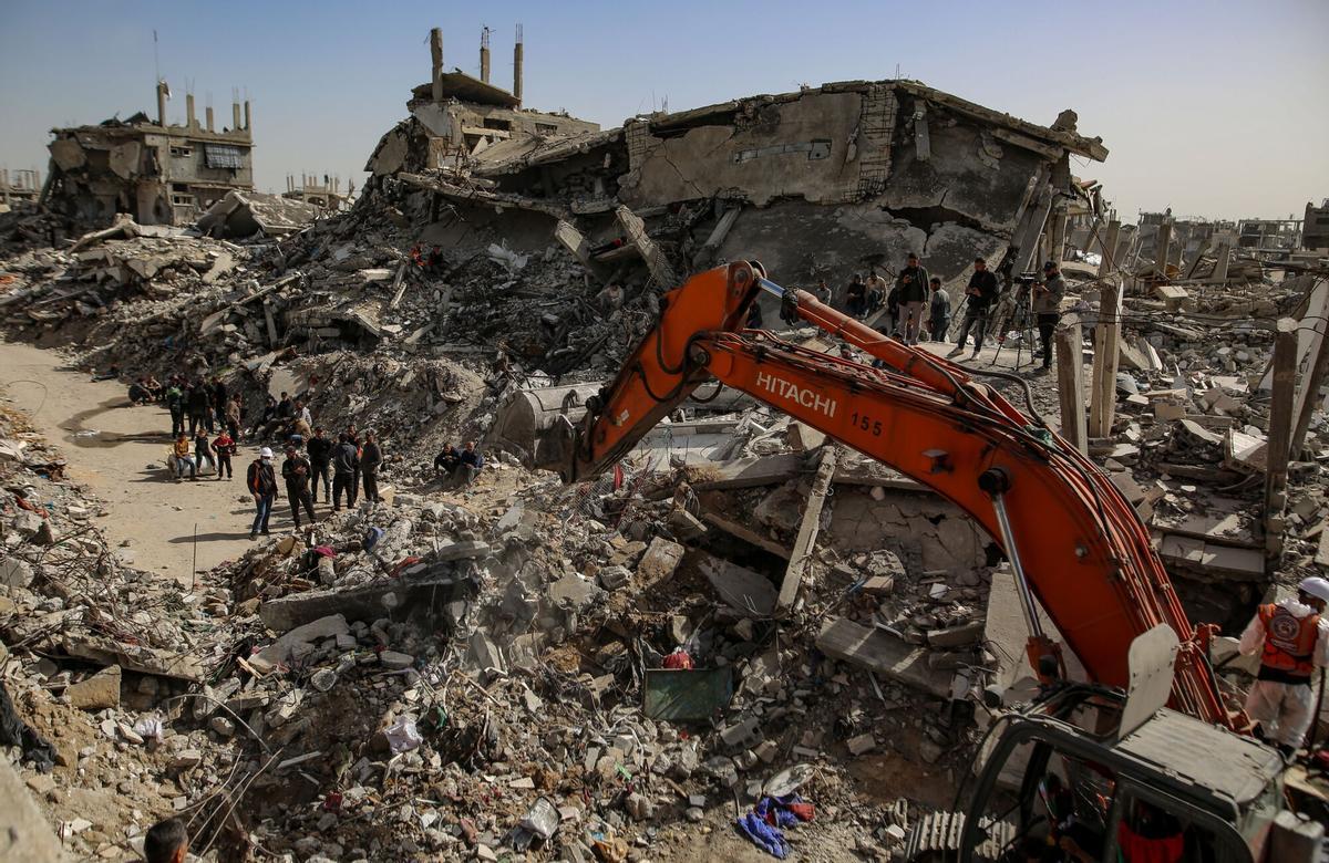 Equipos de la defensa civil palestina trabajan para recuperar cuerpos bajo los escombros, en Beit Lahia, al norte de la Ciudad de Gaza.