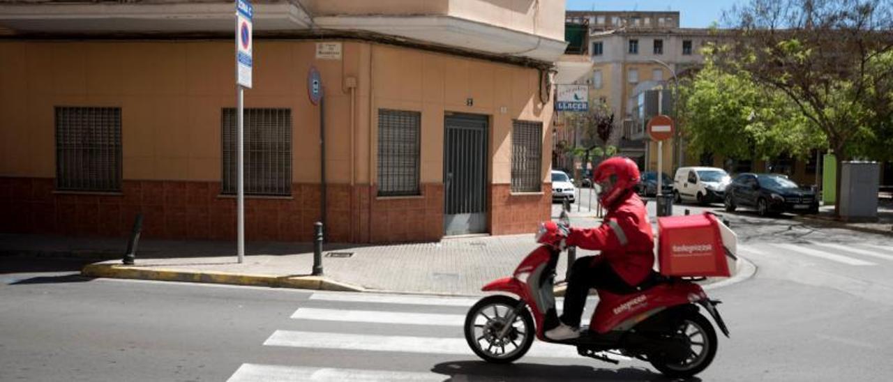 Un repartidor de comida a domicilio, durante el confinamiento en Gandia.