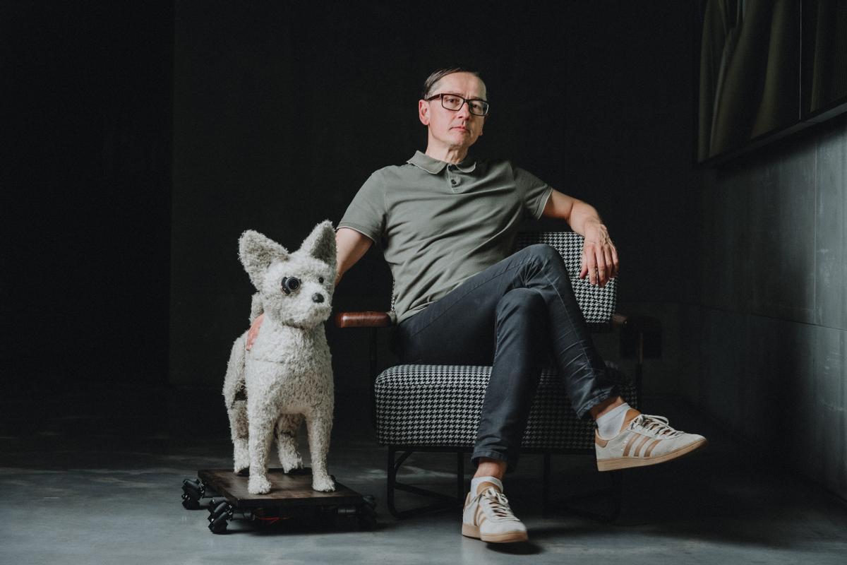 El artista alemán Mario Klingemann con su creación, el perro robot AICCA.