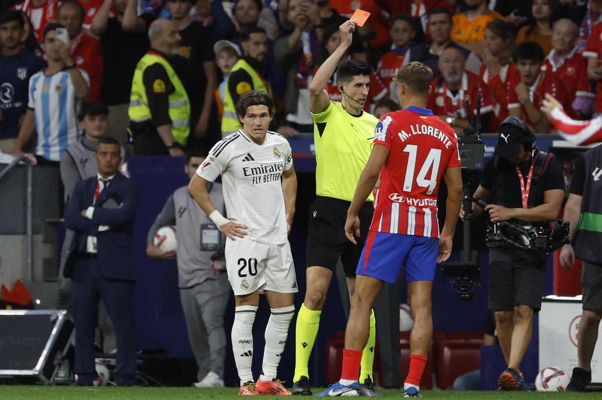 MADRID, 29/09/2024.- El árbitro Busquets Ferrer (c) muestra la tarjeta roja a Marcos Llorente (d), del Atlético, durante el partido de la LaLiga EA Sports que Atlético de Madrid y Real Madrid han disputado este domingo en el estadio Civitas Metropolitano. EFE/JJ Guillén