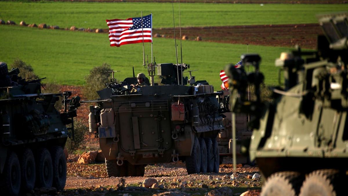 Un convoy de blindados con bandera de EEUU circulan por las afueras de la ciudad de Manbij, en el norte de Siria.