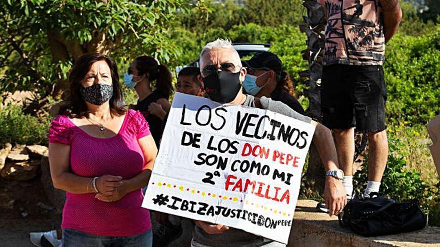 Uno de los allegados de los vecinos, con un pancarta de apoyo.