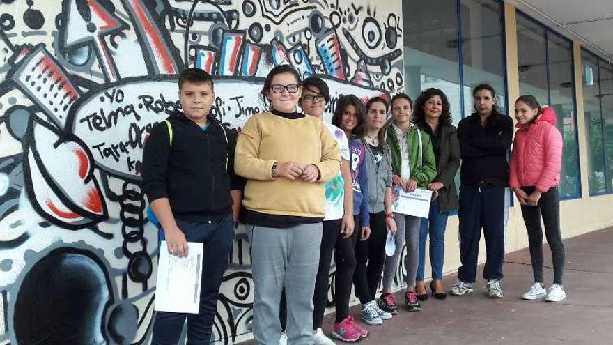 Alumnos del curso de graffiti posan junto a su mural. // FdV