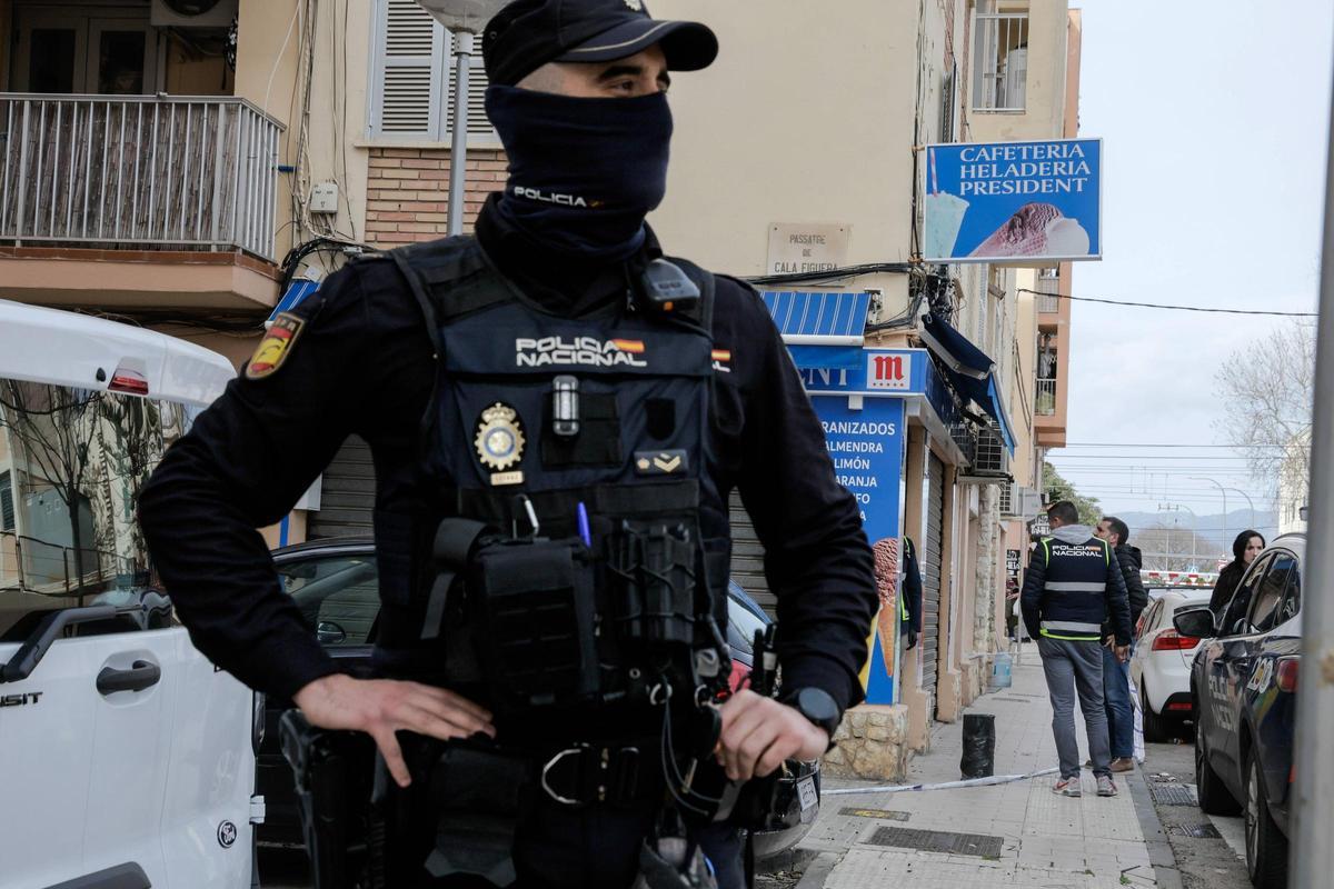Un agente de la Policía Nacional ante el bar de la calle Greco de Palma donde ha habido el tiroteo.