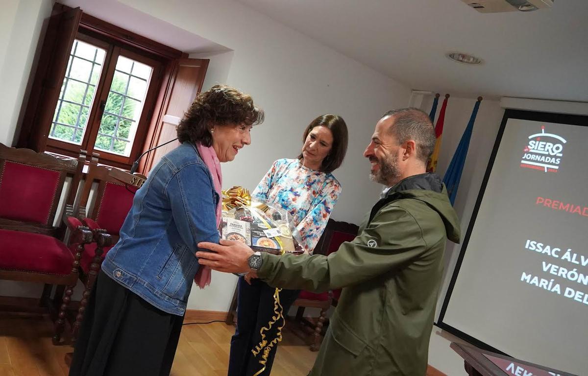 Alicia Cardoso recibe de manos de Ángel García un lote de productos asturianos por su participación en el certamen.